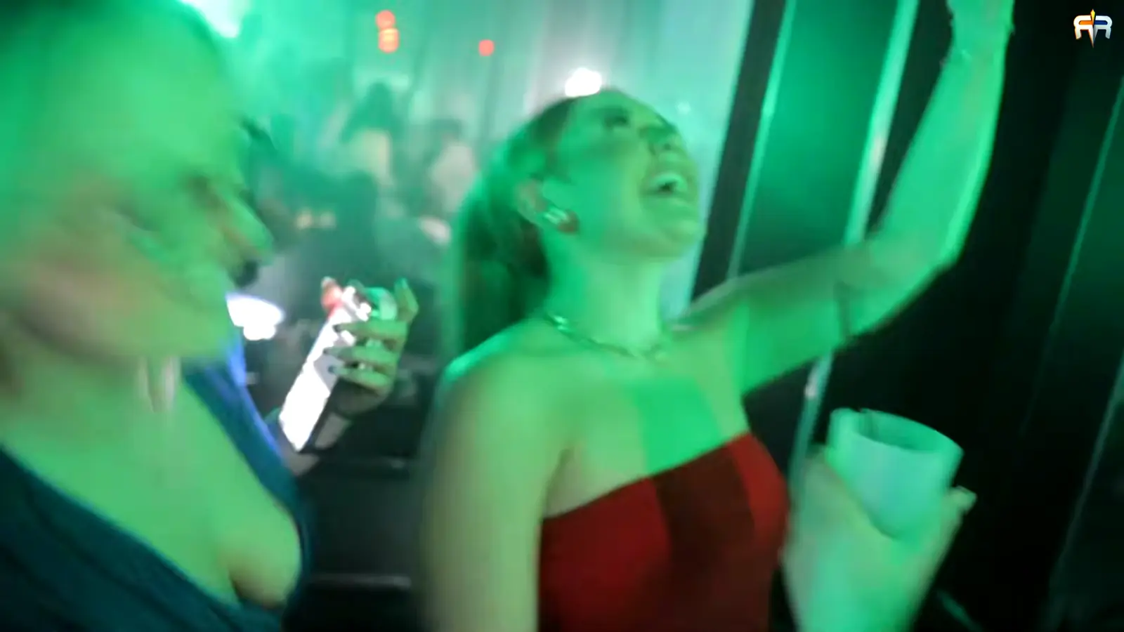 Dve devojke plešu u zelenom svetlu